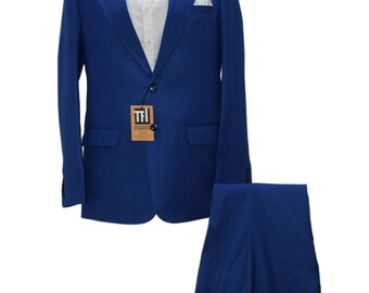May include: A formal blue suit displayed on a mannequin. The suit includes a blazer, trousers, a white dress shirt, a black bow tie, and a white pocket square. A tag with text is attached to the blazer. The suit is a solid color.
