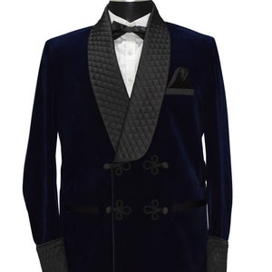 Könnte beinhalten: Ein marineblauer Samtblazer mit schwarzem Satin-Schal-Kragen und gestepptem Futter. Der Blazer hat einen zweireihigen Verschluss mit dekorativen Kordelknöpfen und schwarzem Satinbesatz.