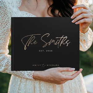Personalized wedding guest book in black with elegant gold foil design, perfect for a classic wedding ceremony and reception. This custom wedding gift doubles as a timeless wedding album, anniversary gift, and keepsake memory book for guests to sign and leave wishes. A minimalist yet luxurious design fits boho, elegant, and traditional wedding themes, making it the ideal way to preserve love stories and celebrate the couple’s special day for years to come.
