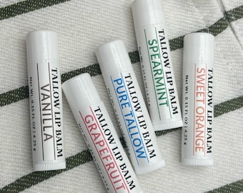 Könnte beinhalten: Fünf weiße Lippenbalsam-Tuben mit verschiedenen Geschmacksrichtungen: Vanille, Grapefruit, Pure Tallow, Spearmint und Sweet Orange. Jede Tube hat ein Etikett mit dem Geschmacksnamen und den Worten "Tallow Lip Balm".