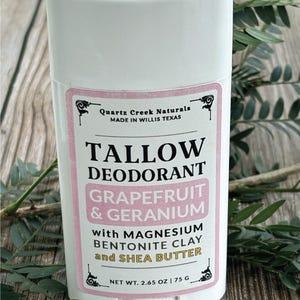K&ouml;nnte beinhalten: Ein wei&szlig;er, zylindrischer Deodorant-Stick mit einem Etikett, das Quartz Creek Naturals, Tallow Deodorant, Grapefruit & Geranium with Magnesium, Bentonite Clay and Shea Butter, Nettogewicht 75 g | 2.65 oz, hergestellt in Willis Texas, zeigt.