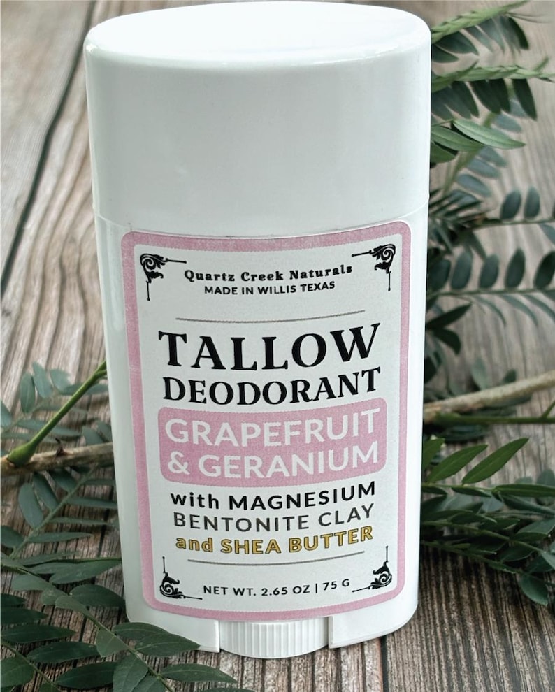K&ouml;nnte beinhalten: Ein wei&szlig;er, zylindrischer Deodorant-Stick mit einem Etikett, das Quartz Creek Naturals, Tallow Deodorant, Grapefruit & Geranium with Magnesium, Bentonite Clay and Shea Butter, Nettogewicht 75 g | 2.65 oz, hergestellt in Willis Texas, zeigt.