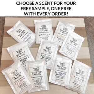 May include: A selection of small, silver, foil-wrapped packages of whipped tallow skin cream. Each package features a different scent, including Lavender + Vanilla, Cedarwood, Rosemary + Tea Tree, and Winter Forest. The packages are arranged on a wooden surface. Choose a scent for your free sample, one free with every order!