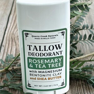 K&ouml;nnte beinhalten: Ein wei&szlig;er, zylindrischer Deodorant-Stick mit einem gr&uuml;n-wei&szlig;en Etikett. Der Text lautet Quartz Creek Naturals, Tallow Deodorant, Rosemary & Tea Tree with Magnesium, Bentonite Clay and Shea Butter, Net Wt. 2.65 oz | 75 g.