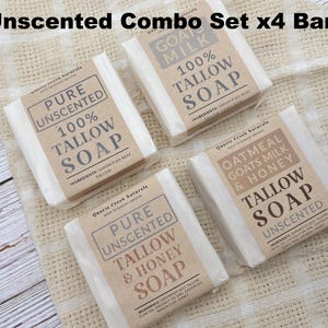 May include: A set of four rectangular bars of tallow soap wrapped in white paper with tan labels. The labels feature the text Quartz Creek Naturals, Pure Unscented, 100% Tallow Soap, Oatmeal Goats Milk & Honey, and Tallow & Honey Soap.