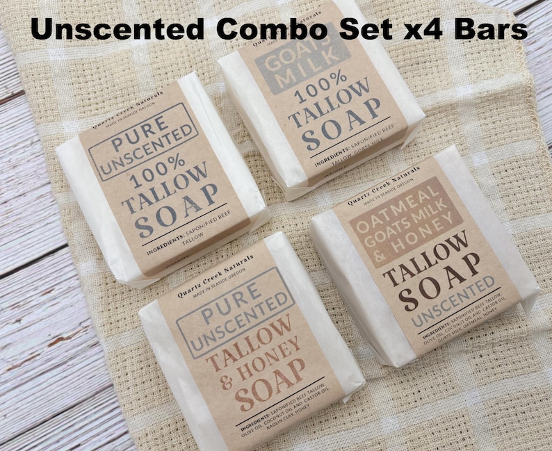 May include: A set of four rectangular bars of tallow soap wrapped in white paper with tan labels. The labels feature the text Quartz Creek Naturals, Pure Unscented, 100% Tallow Soap, Oatmeal Goats Milk & Honey, and Tallow & Honey Soap.