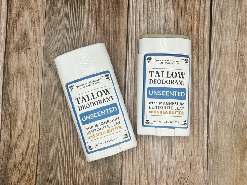 K&ouml;nnte beinhalten: Zwei wei&szlig;e Deodorant-Stifte aus Kunststoff mit blau-wei&szlig;en Etiketten. Der Text lautet Quartz Creek Naturals, Tallow Deodorant, Unscented, with Magnesium, Bentonite Clay and Shea Butter, Net Wt. 2.65 oz | 75 g. Die Beh&auml;lter haben einen Drehmechanismus.