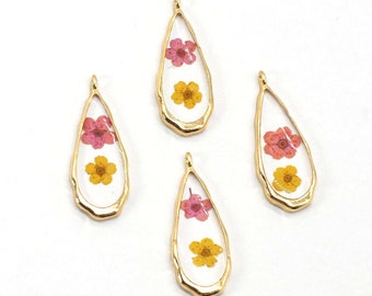 May include: Four gold teardrop-shaped charms with clear resin and pressed pink and yellow flowers inside.