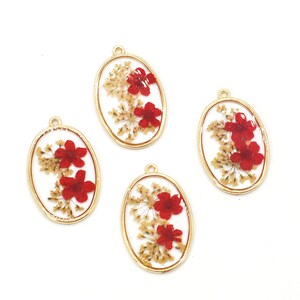 May include: Four gold oval-shaped charms with a clear resin background and dried red flowers and tan foliage inside.
