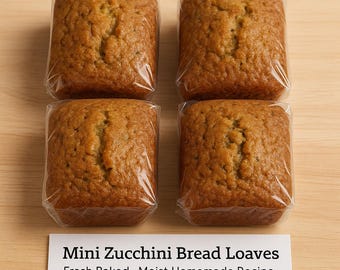 May include: Four mini zucchini bread loaves, individually wrapped in clear plastic. The loaves are golden brown with a textured surface. A white sign at the bottom reads "Mini Zucchini Bread Loaves Fresh Baked - Moist Homemade Recipe."