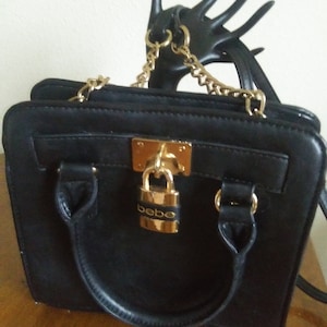Cartera o bolso de hombro vintage Bebe de cuero negro con cadena dorada y correa de cuero, y cierre dorado, 20 cm de alto x 20 cm de ancho