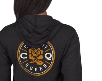 Puede incluir: Una sudadera con capucha gris oscuro con cremallera y un logotipo circular en la espalda. El logotipo presenta una rosa estilizada con el texto "Country Queer" alrededor.