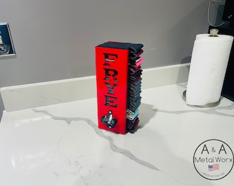 May include: A red wooden bottle opener and cap catcher with the name "FRYE" cut out. The bottle opener is mounted on the front, and the back is filled with colorful bottle caps. The product is on a white countertop.