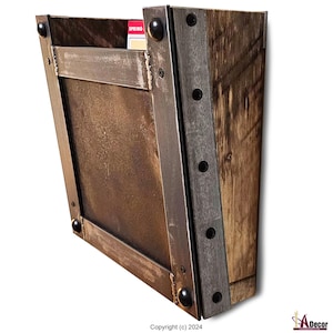 May include: A rustic metal and wood wall mounted mail organizer with a metal frame and a wooden back. The organizer has a single slot for mail and is secured to the wall with screws.