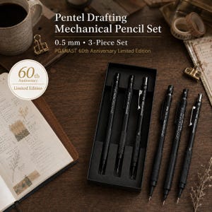 Op de afbeelding: Een Pentel technisch vulpotloodset met drie 0,5 mm potloden in een zwarte doos. De set is gelabeld als een PGANAST 60th Anniversary Limited Edition. De potloden zijn zwart met metalen clips en getextureerde grepen voor nauwkeurig tekenwerk.