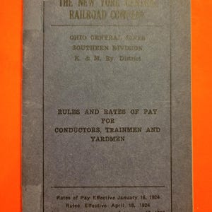 May include: A blue cover for a rules and rates of pay booklet for conductors, trainmen, and yardmen. The booklet is for the New York Central Railroad Company, Ohio Central Lines, Southern Division, K. & M. Ry. District. The rates of pay are effective January 16, 1924, and the rules are effective April 18, 1924. The booklet supersedes the agreement of January 12, 1923.