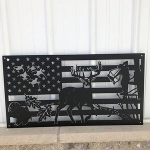 May include: Black metal wall art featuring a deer, turkey, and bear silhouetted against an American flag design.