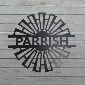 May include: Black metal silhouette of a windmill with the name "PARRISH" in the center. The design is reminiscent of a traditional farm windmill.