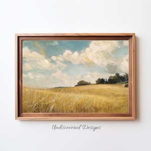 May include: A framed painting of a landscape with a field of golden wheat in the foreground, a line of trees in the distance, and a blue sky with white clouds.