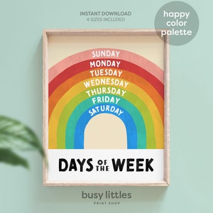 May include: A printable rainbow-themed poster with the days of the week written in a retro font. The poster is framed in a light wood frame and has the text "Days of the Week" at the bottom.