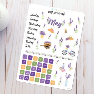 May include: A sticker sheet with a lavender theme for a May journal. It includes a calendar, days of the week, lavender flowers, a bicycle, and a basket of lavender.