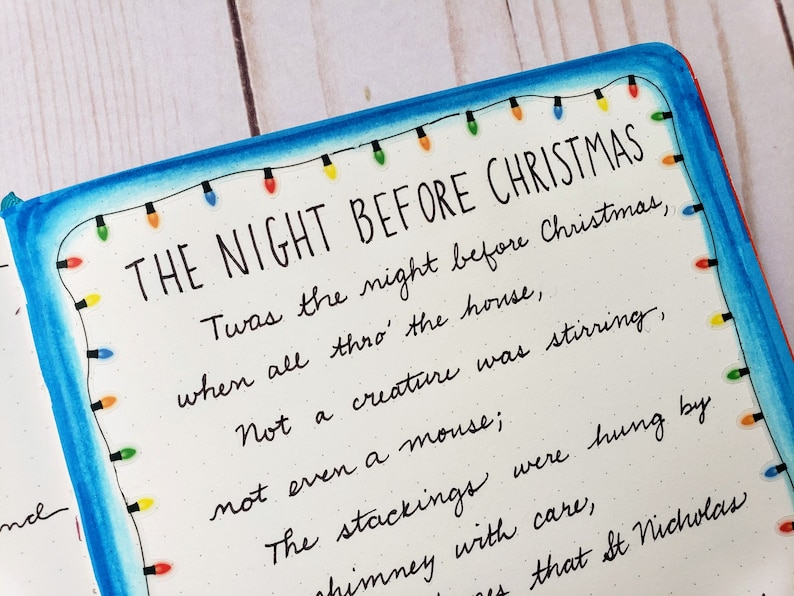 Puede incluir: Una p&aacute;gina con el texto THE NIGHT BEFORE CHRISTMAS seguido de las primeras l&iacute;neas del poema en tinta negra. El borde est&aacute; decorado con una guirnalda de luces navide&ntilde;as dibujada a mano en rojo, naranja, verde y azul sobre fondo blanco.