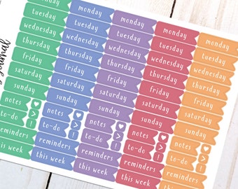May include: A sticker sheet featuring five vertical columns of flag-shaped labels in green, blue, purple, red, and orange. Each column contains the days of the week from Monday to Sunday, followed by labels for notes, to-do, reminders, and this week.