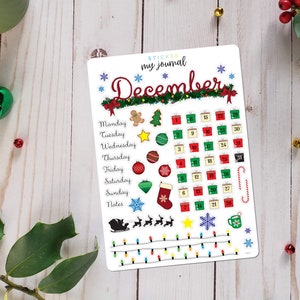May include: A white sticker sheet with a December calendar and Christmas-themed illustrations. The calendar features a grid with numbers 1 through 30, and the illustrations include presents, ornaments, a gingerbread man, a stocking, and a snowflake.