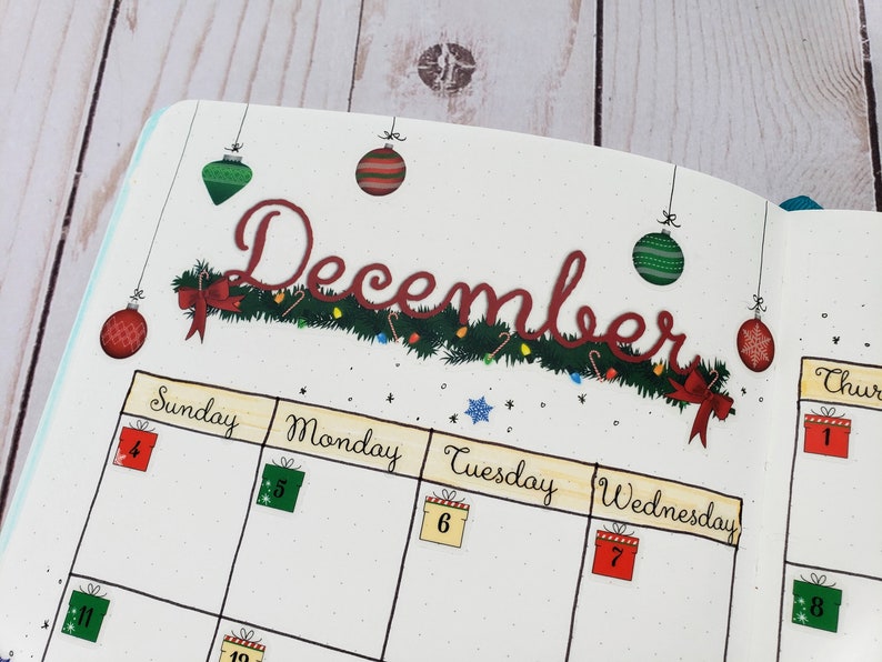 May include: A December calendar page with a green garland and red ornaments. The days of the week are labeled Sunday, Monday, Tuesday, Wednesday, and Thursday. The numbers 4, 5, 6, 7, 1, and 8 are written in boxes on the calendar.