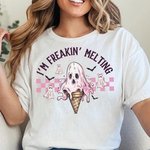 Puede incluir: Camiseta blanca con un gr&aacute;fico rosa y negro de un fantasma derriti&eacute;ndose en un cono de helado. El texto "I'm Freakin' Melting" est&aacute; escrito en un c&iacute;rculo negro alrededor del gr&aacute;fico.