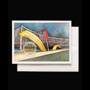 May include: Watercolor painting of a yellow bridge with a red arrow on top. The bridge is over a body of water and there is a green grassy area in the foreground. The painting is signed "Stephen Boyd" in the bottom right corner. The text "The Watercolor Art of The Prairie Artist" is in a gold circle in the bottom left corner.