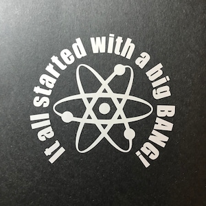 May include: White vinyl sticker with a black background. The sticker features a stylized atom with the text "It all started with a big BANG!" around it.
