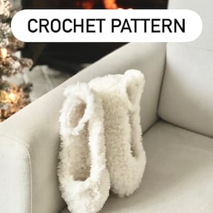 May include: A pair of fluffy white slippers with a textured appearance, resting on a light-colored sofa. The image includes text that reads "CROCHET PATTERN" and "DIGITAL DOWNLOAD". The slippers appear soft and cozy.
