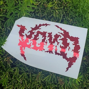 May include: A white sticker with a red and pink design of the word "WORM" in a jagged, flame-like font.
