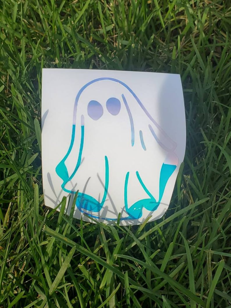 May include: A white ghost sticker with blue and purple accents. The ghost is outlined in blue and has two eyes.