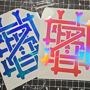 May include: Two stickers with a geometric design. One is blue with a marbled effect, the other is red with a rainbow holographic effect. The stickers are on a white backing, and the background is a black grid.