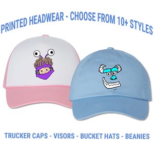 May include: Two hats with cartoon character designs. One is a white and pink trucker hat with a cartoon character face. The other is a light blue baseball cap with a cartoon character face. Text on the image reads: PRINTED HEADWEAR - CHOOSE FROM 10+ STYLES and TRUCKER CAPS - VISORS - BUCKET HATS - BEANIES.