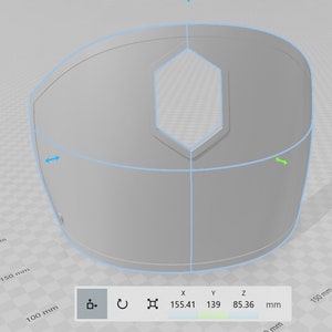 May include: A 3D model of a gray, curved, hexagonal shape with a hole in the center. The model is 155.41 mm wide, 139 mm tall, and 85.36 mm deep.