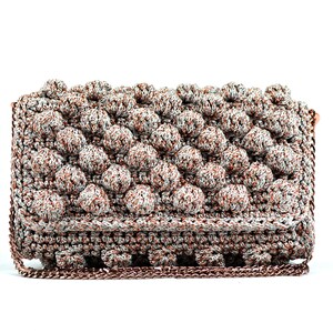 May include: A silver and copper crocheted clutch bag with a chain strap.