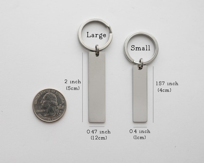 K&ouml;nnte beinhalten: Zwei silberne Schl&uuml;sselanh&auml;nger mit rechteckigen Anh&auml;ngern. Der gr&ouml;&szlig;ere Schl&uuml;sselanh&auml;nger ist 5 cm lang und 1,2 cm breit. Der kleinere Schl&uuml;sselanh&auml;nger ist 4 cm lang und 1 cm breit. Die Schl&uuml;sselanh&auml;nger sind mit "Large" und "Small" beschriftet.