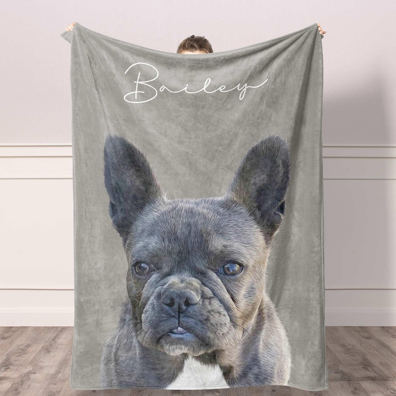 May include: A soft gray fleece blanket featuring a large, detailed portrait of a French Bulldog with dark fur and a white chest patch. The name Bailey is printed in a white, elegant cursive script font across the top portion of the blanket.