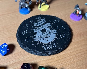 May include: Black slate coaster with a white design of a lute with musical notes and the word "Bard".