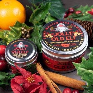 May include: A silver candle tin with a red and black label that reads "Jolly Old Elf" 100% Natural Soy Wax Candle. The candle is surrounded by cinnamon sticks, cranberries, and a red poinsettia.