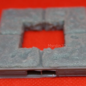 May include: A light gray, square-shaped 3D-printed model with a central opening. The model has a textured surface and appears to be a section of a building or structure. The text "Myrdin3D" is visible on the side.