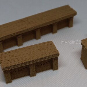 May include: Three wooden miniature benches, one straight, one rectangular, and one curved, with a textured wood grain finish. The benches are brown and have a rustic look. The text "Myrdin3D" is visible on the white surface.