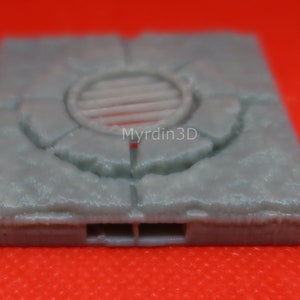 May include: A gray 3D printed model of a sewer grate with a circular opening and a textured surface.