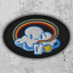 Peut inclure: Un patch brodé noir avec un nuage blanc tenant une tasse bleue avec un arc-en-ciel qui en sort.