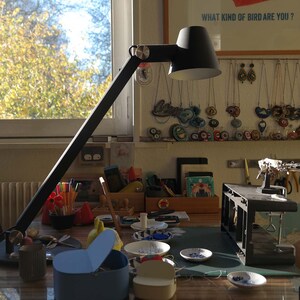 Puede incluir: Un espacio de trabajo con una l&aacute;mpara de escritorio, una mesa con diversos materiales de artesan&iacute;a y una pared decorada con collares coloridos y el texto "&iquest;Qu&eacute; tipo de p&aacute;jaro eres?"