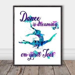 May include: A watercolour print featuring a dancer in mid-air, surrounded by blue and purple paint splatters. The text reads "Dance is dreaming on your toes."