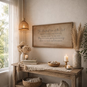 Puede incluir: Un letrero de pared rectangular de madera con el texto impreso en negro: The Steadfast love of the Lord NEVER CEASES HIS MERCIES NEVER COME TO AN END they are new every morning: GREAT IS YOUR FAITHFULNESS LAMENTATIONS 3:22-23.